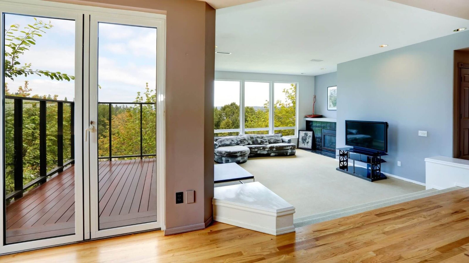 Modern living room with large glass uPVC doors featuring sleek uPVC door handles opening to a scenic balcony view.