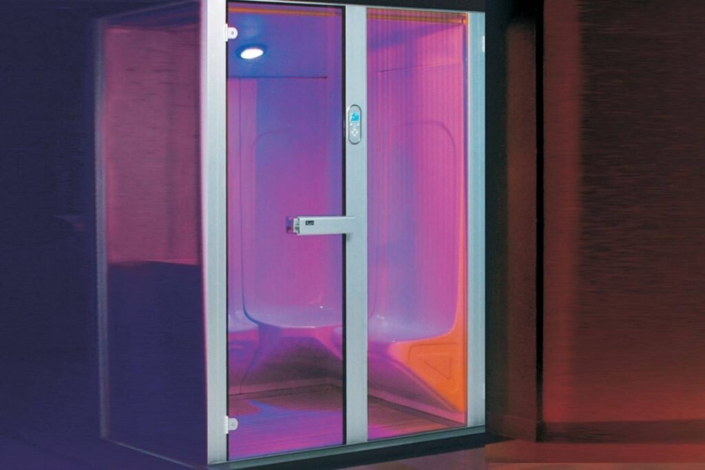 Modern glass-enclosed infrared sauna cabin with ambient lighting, highlighting sauna benefits for relaxation, detox, and home wellness.