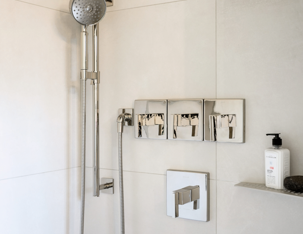 Concealed shower diverter installation showing wall-mounted mixer, hand shower, and premium control panel in a modern bathroom.