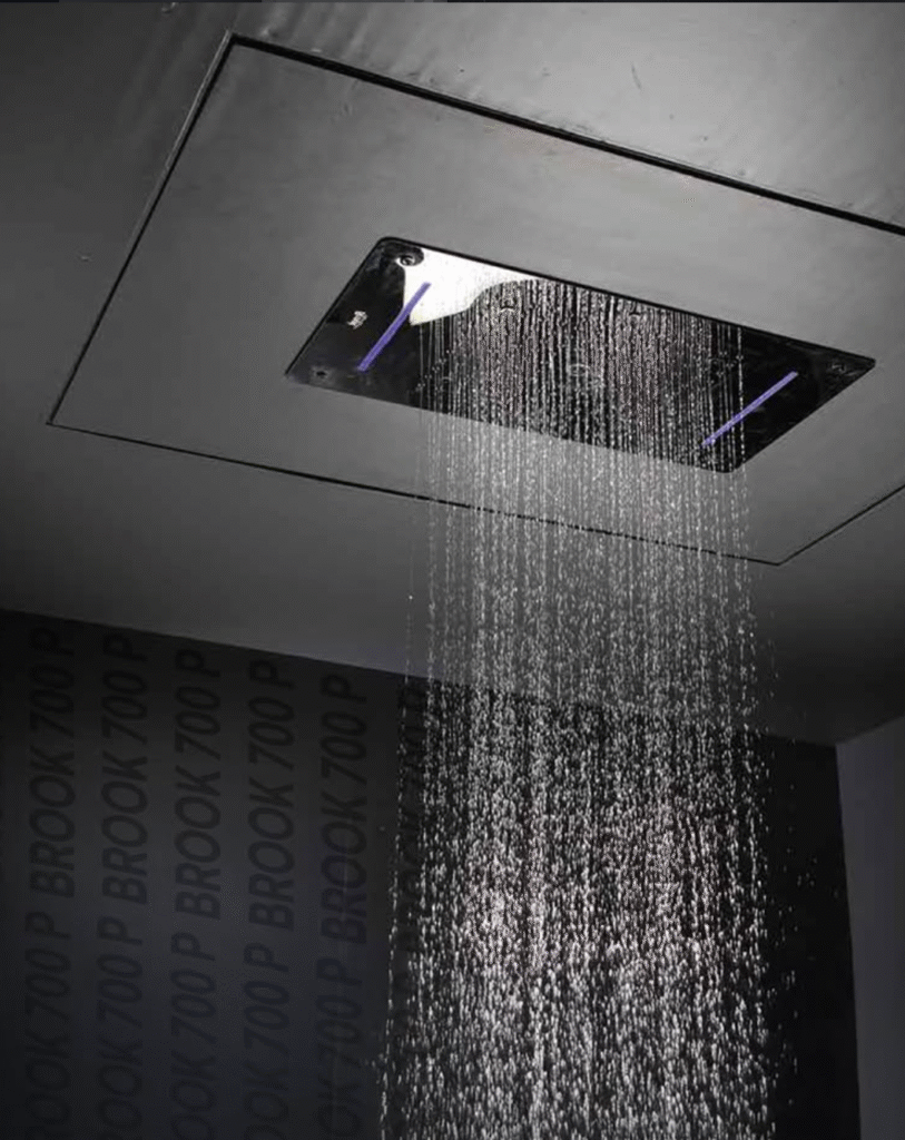 Ceiling-mounted square rainfall shower head with integrated LED lighting and chrome finish releasing a steady rain-like water stream, designed for modern luxury bathrooms and spa-inspired shower experiences.